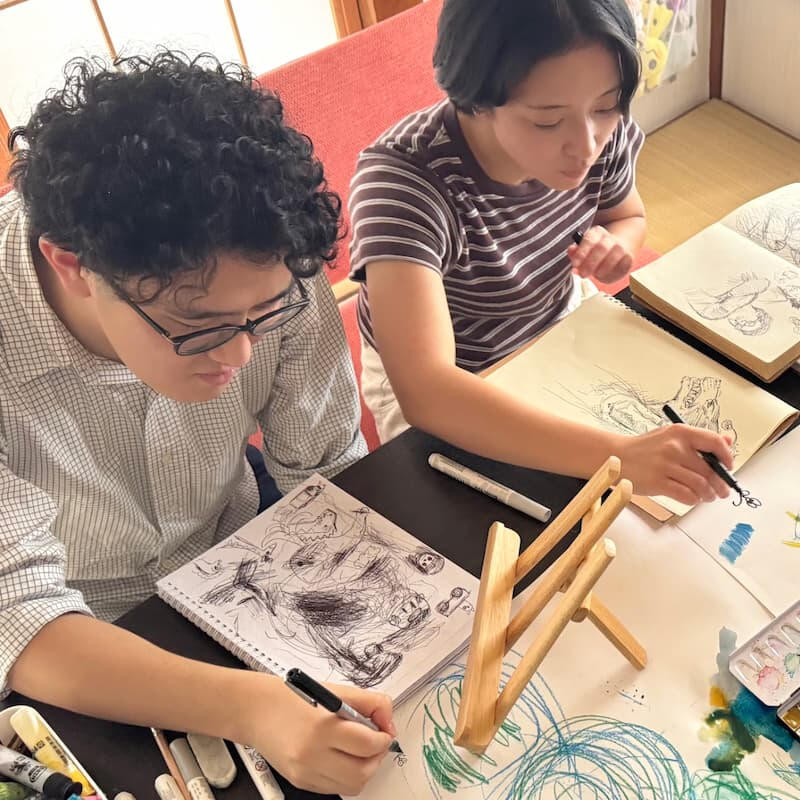 鎌ヶ谷のお絵描き教室で、テーブルに向かって絵を描く受講生